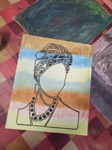ACAP Made painted canvas: black stencilled outline of a woman in a patterned head wrap and bead necklace over painted bands of blue, yellow, orange and pink