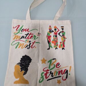 ACAP Made cream tote bag stencilled with "You matter the most", "Be strong!", three women carrying pots and a woman with an updo, in red, green, gold and black